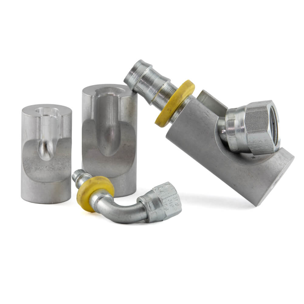 3 Barb-Tech Tool Mandrels that hold 45 and 990 degree push-lok fittings. One fitting is in front and another fitting is in the mandrel.